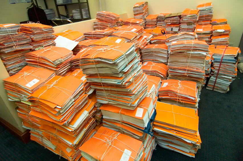Many piles of folders in backroom office