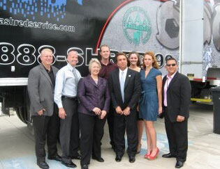 Group of people standing alongside company truck