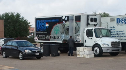 Boxes stacked alongside the shredding truck with a tech